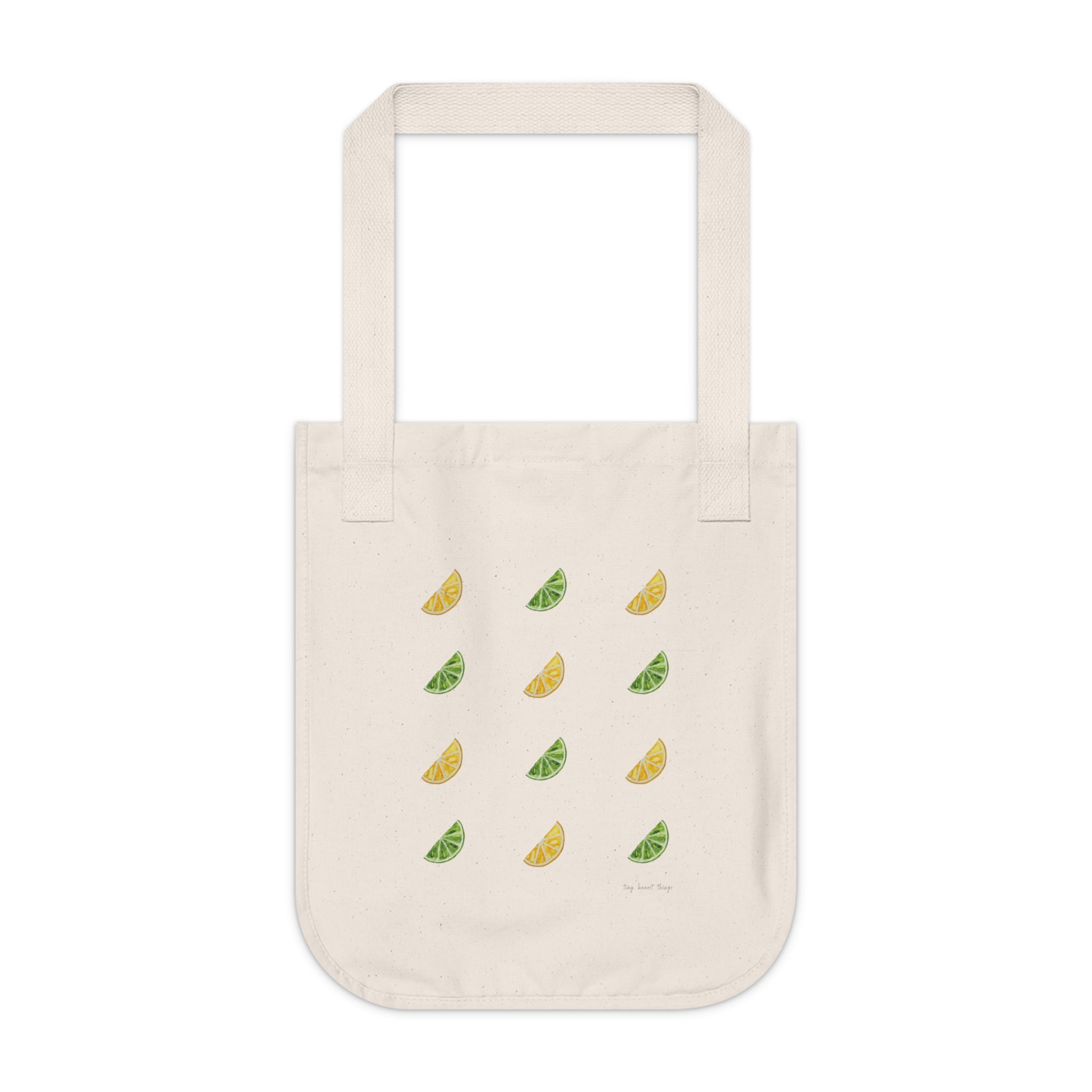 Beige tote bag with lemon and lime illustrations on a white background